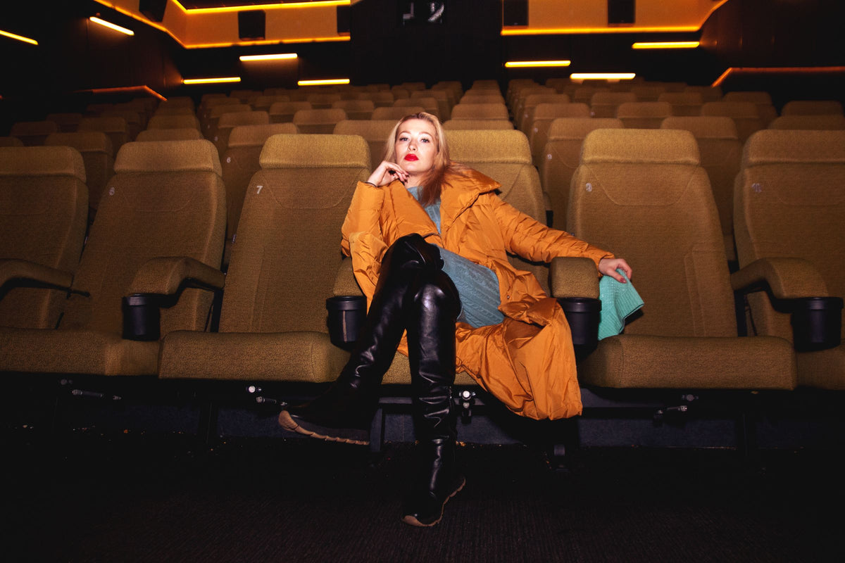 Woman in orange coat and black leather boots