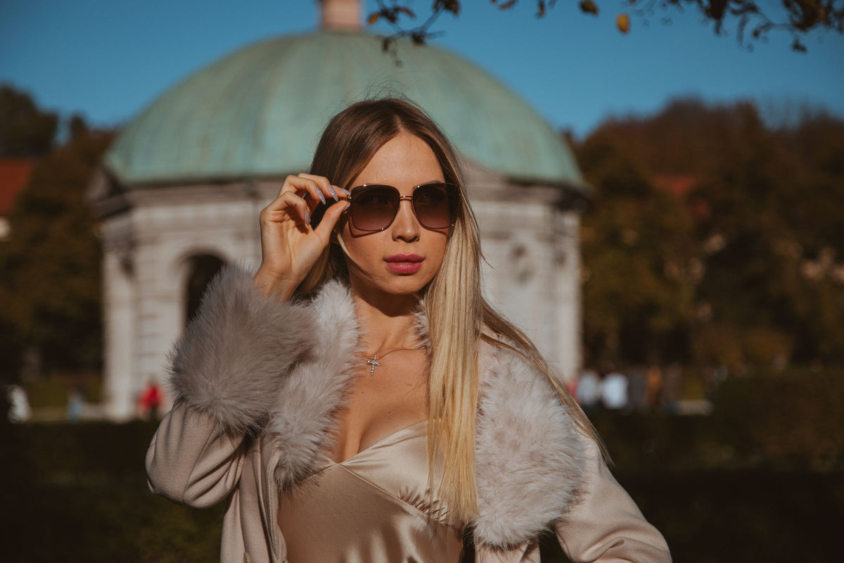 Woman in fur-trimmed coat and sunglasses